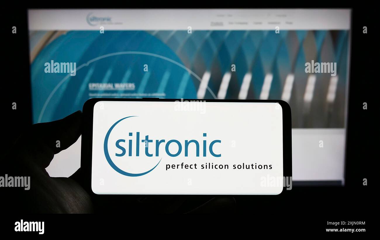 Stuttgart, 24.01.2023: Person, die ein Mobiltelefon mit dem Logo des deutschen Elektronikunternehmens Siltronic AG auf dem Bildschirm vor der Business-Website hält. Stockfoto