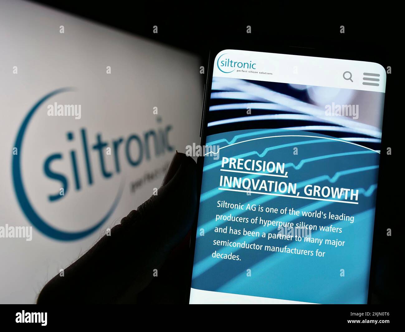 Stuttgart, 24.01.2023: Handybesitzer mit Webseite des deutschen Elektronikunternehmens Siltronic AG auf dem Bildschirm vor dem Logo. Konzentrieren Sie sich auf Stockfoto