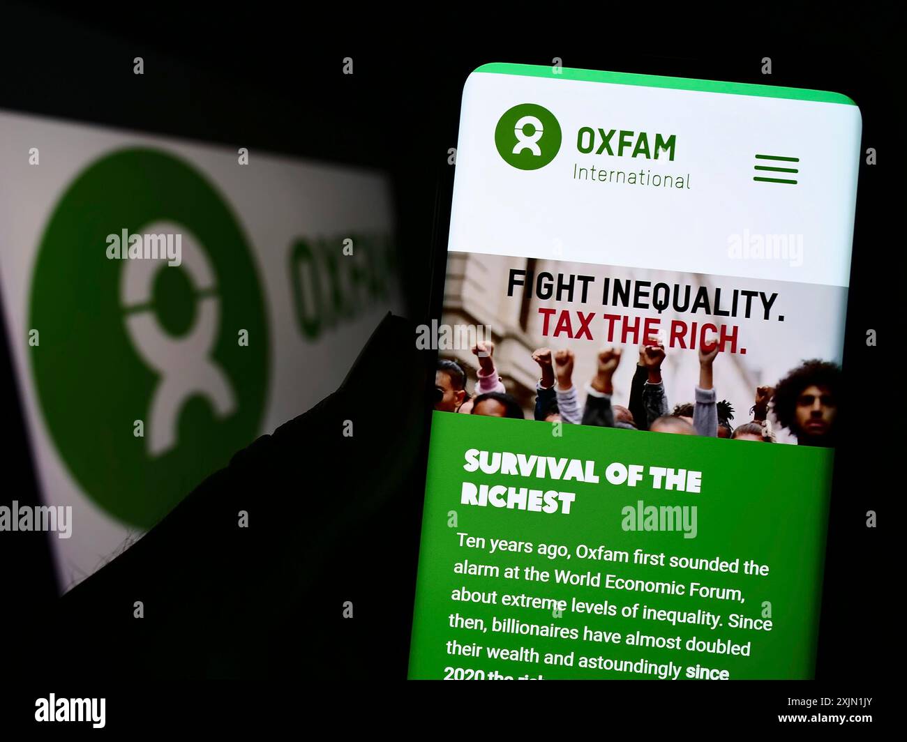 Stuttgart, Deutschland, 21.01.2023: Person, die ein Smartphone hält, mit Website des konföderationsverbandes Oxfam International vor dem Logo auf dem Bildschirm. Konzentrieren Sie sich auf Stockfoto