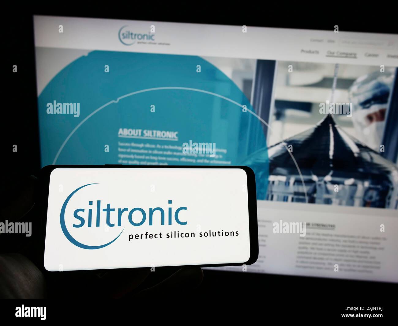 Stuttgart, 24.01.2023: Person, die ein Mobiltelefon mit dem Logo des deutschen Elektronikunternehmens Siltronic AG auf dem Bildschirm vor dem Business Web hält Stockfoto