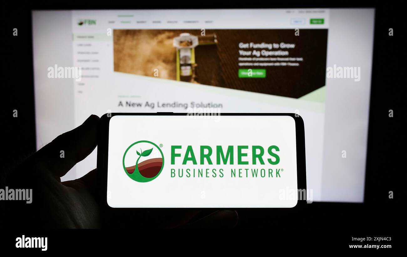 Stuttgart, Deutschland, 03-31-2023: Person mit Smartphone mit Logo der Landwirtschafts-Plattform Farmers Business Network (FBN) vor dem Bildschirm Stockfoto