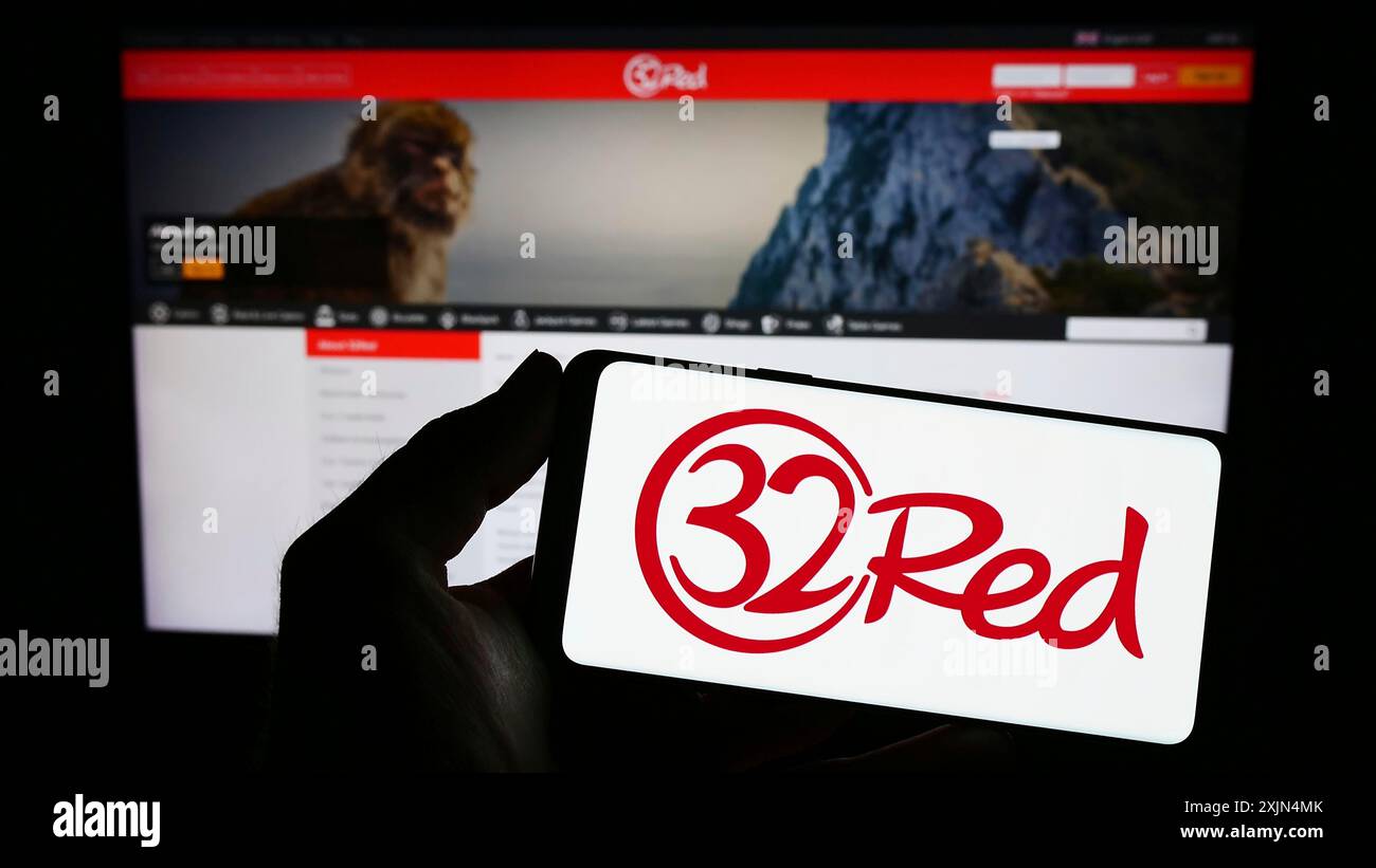 Stuttgart, Deutschland, 04.01.2023: Person, die ein Smartphone mit dem Logo des Online-Casino-Unternehmens 32Red Limited auf dem Bildschirm vor der Website hält. Konzentrieren Sie sich auf Stockfoto