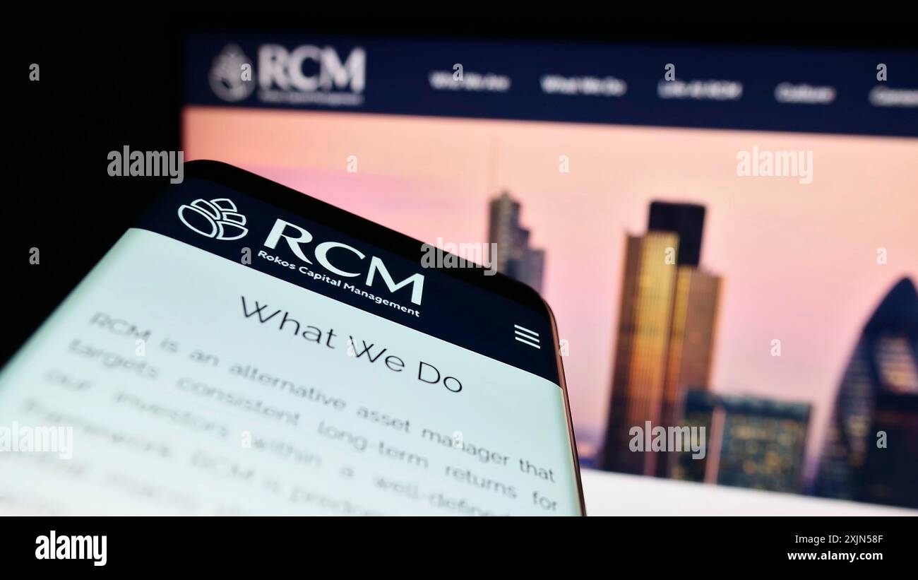 Stuttgart, 24.04.2023: Smartphone mit Webseite und Logo der Firma Rokos Capital Management LLP (RCM) auf dem Bildschirm vor dem Monitor. Fokus Stockfoto