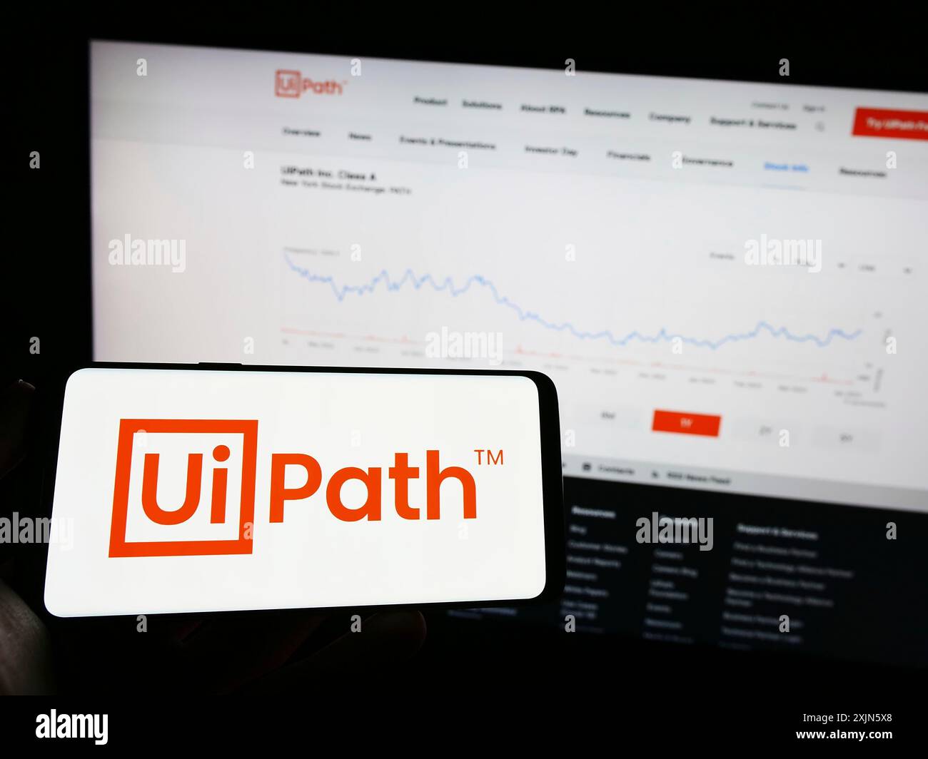 Stuttgart, Deutschland, 04.04.2023: Person, die ein Mobiltelefon mit dem Logo des Automatisierungssoftware-Unternehmens UiPath Inc. Auf dem Bildschirm vor dem Business Web hält Stockfoto