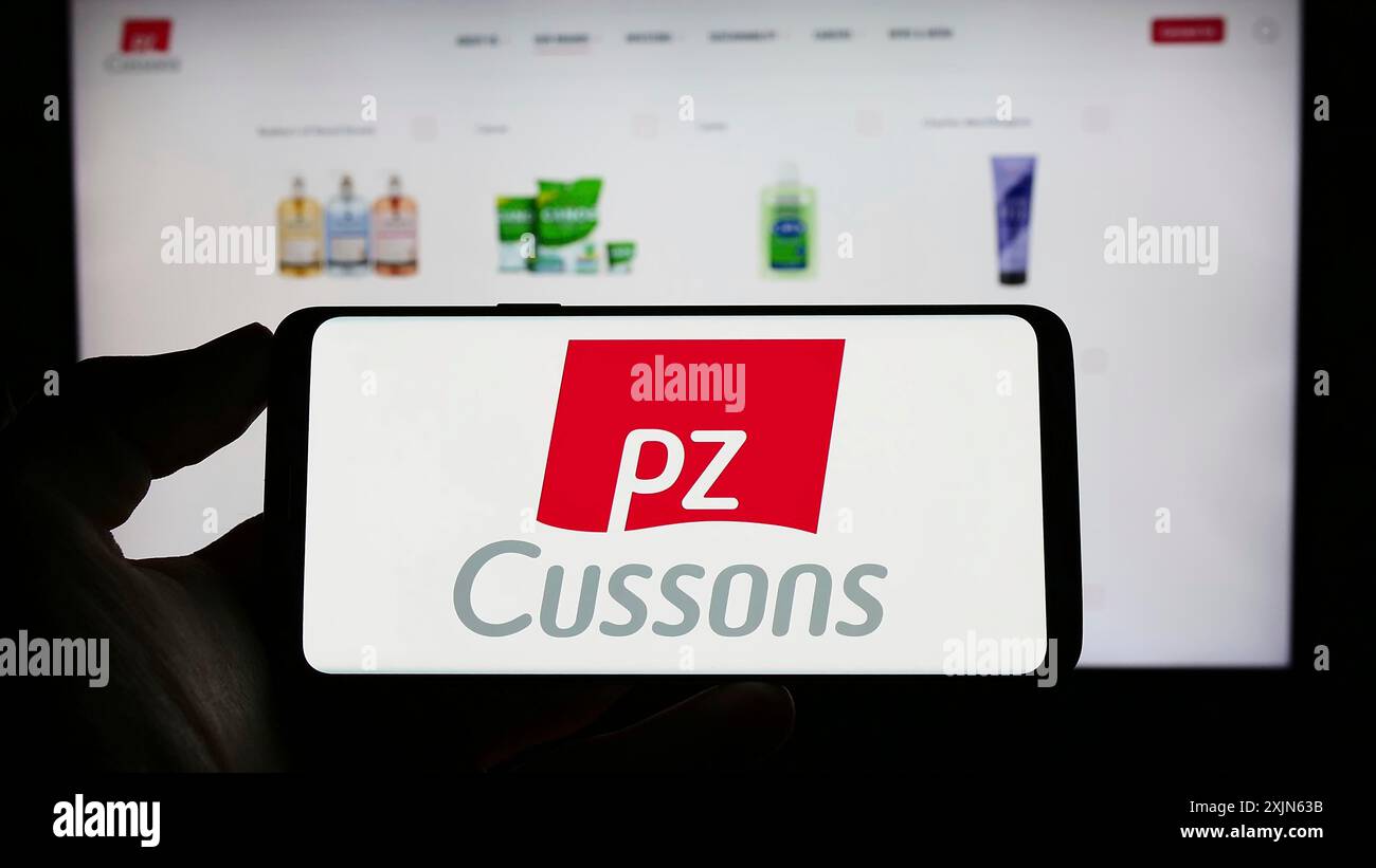 Stuttgart, Deutschland, 20.04.2023: Person, die ein Mobiltelefon mit dem Logo des britischen Konsumgüterunternehmens PZ Cussons plc auf dem Bildschirm vor der Webseite hält. Stockfoto