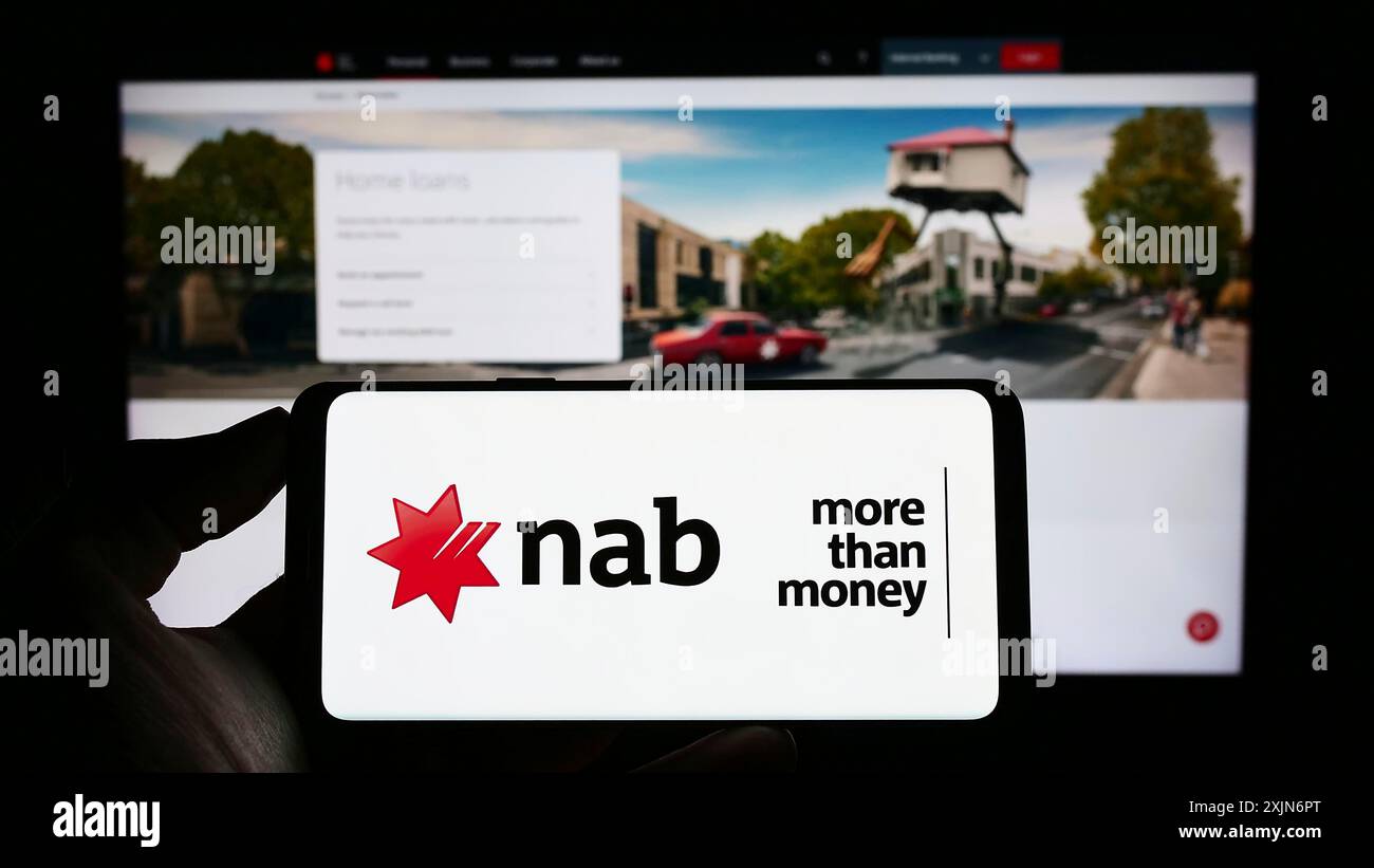 Stuttgart, Deutschland, 17.03.2023: Person, die ein Mobiltelefon mit dem Logo der National Australia Bank Limited (NAB) auf dem Bildschirm vor der Webseite hält. Stockfoto