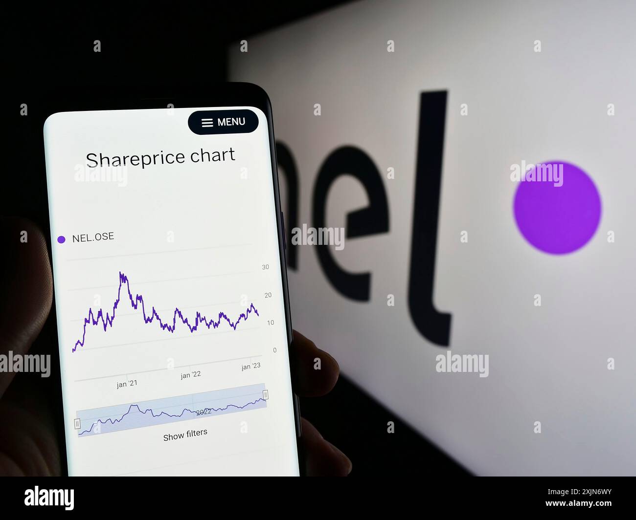 Stuttgart, Deutschland, 19.03.2023: Person, die ein Mobiltelefon hält, mit Website des norwegischen Wasserstoffunternehmens Nel ASA auf dem Bildschirm vor dem Geschäftslogo. Stockfoto