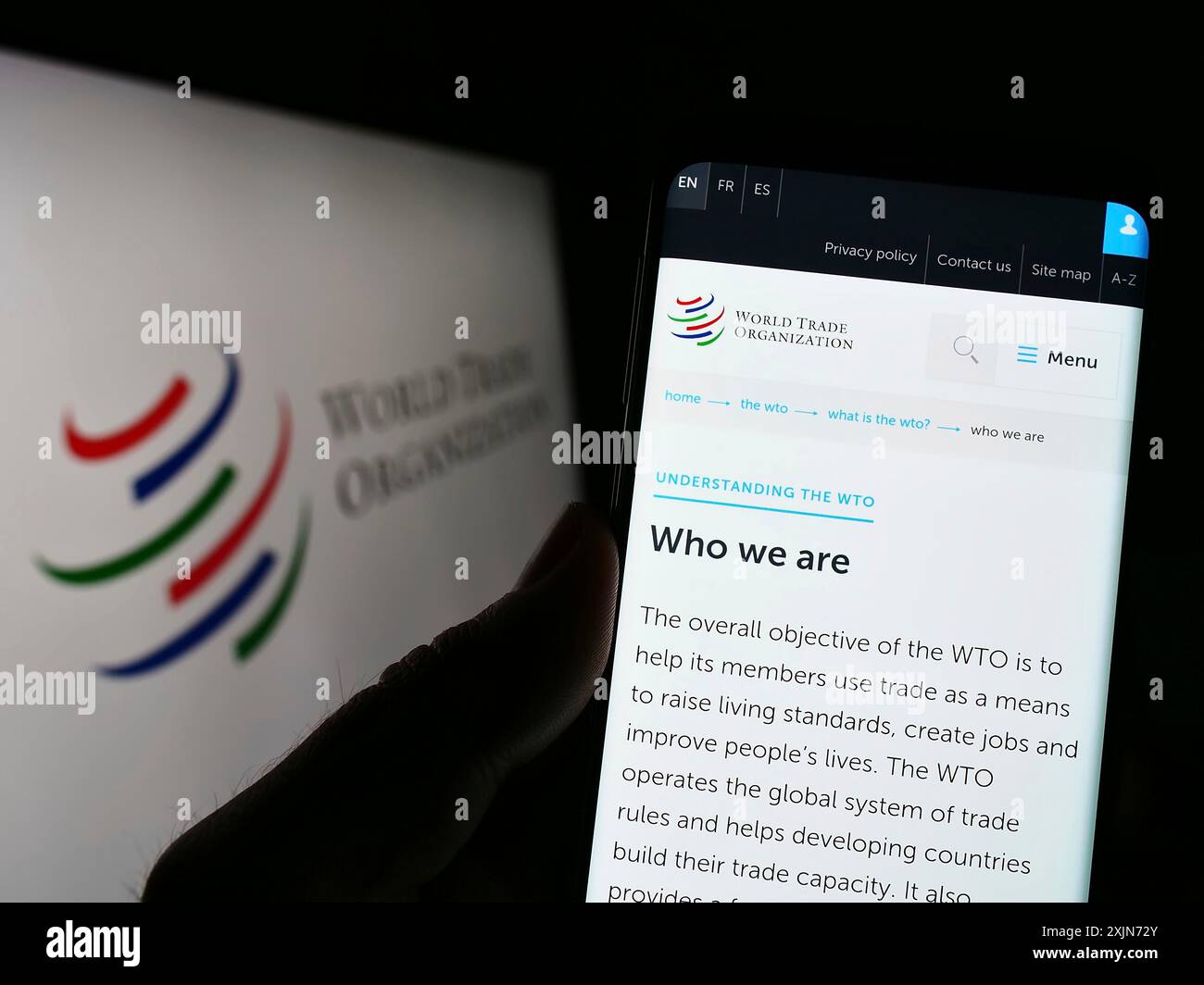 Stuttgart, Deutschland, 25.03.2023: Person, die ein Mobiltelefon hält, mit einer Webseite der Welthandelsorganisation (WTO) vor dem Logo auf dem Bildschirm. Konzentrieren Sie sich auf die Mitte Stockfoto Stuttgart, Deutschland, 25.03.2023: Person, die ein Mobiltelefon hält, mit einer Webseite der Welthandelsorganisation (WTO) vor dem Logo auf dem Bildschirm. Konzentrieren Sie sich auf die Mitte Stockfoto