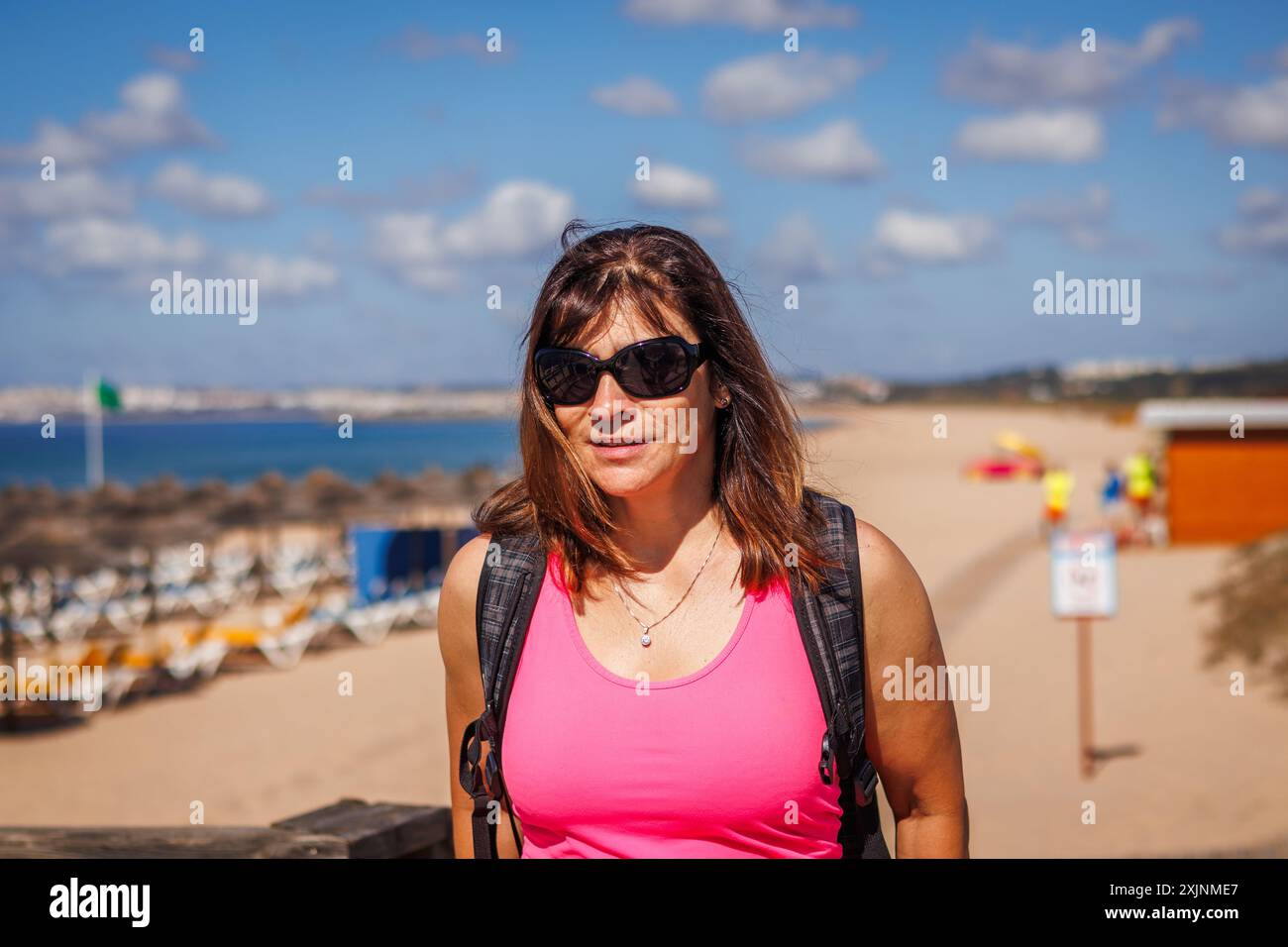 Eine fitte und vitale reife Frau geht an sonnigen Tagen an den Strand. Badeurlaub und Sommerurlaub in der Algarve, Portugal. Stockfoto
