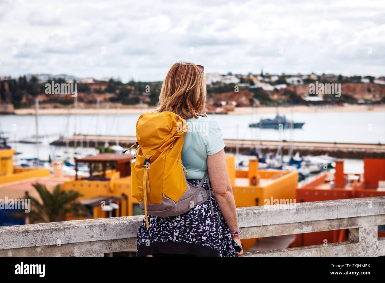 Frau Touristin mit Rucksack, die Portimao Stadt während des Urlaubs in der Algarve, Portugal, erkundet. Alleinreisen Stockfoto