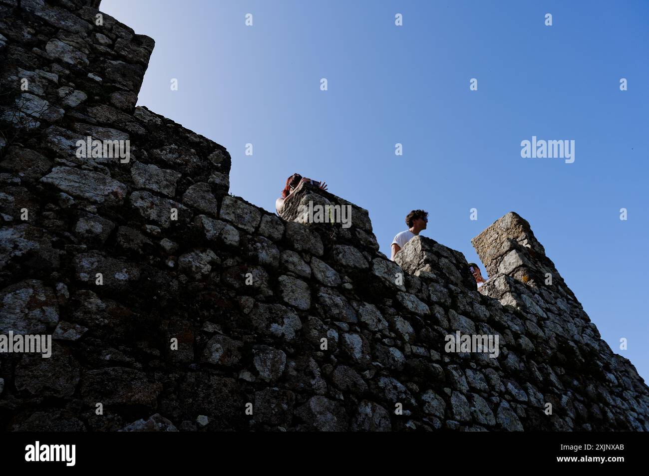 Menschen gegen den blauen Himmel auf den Steinmauern der maurischen Burg in Sintra Stockfoto