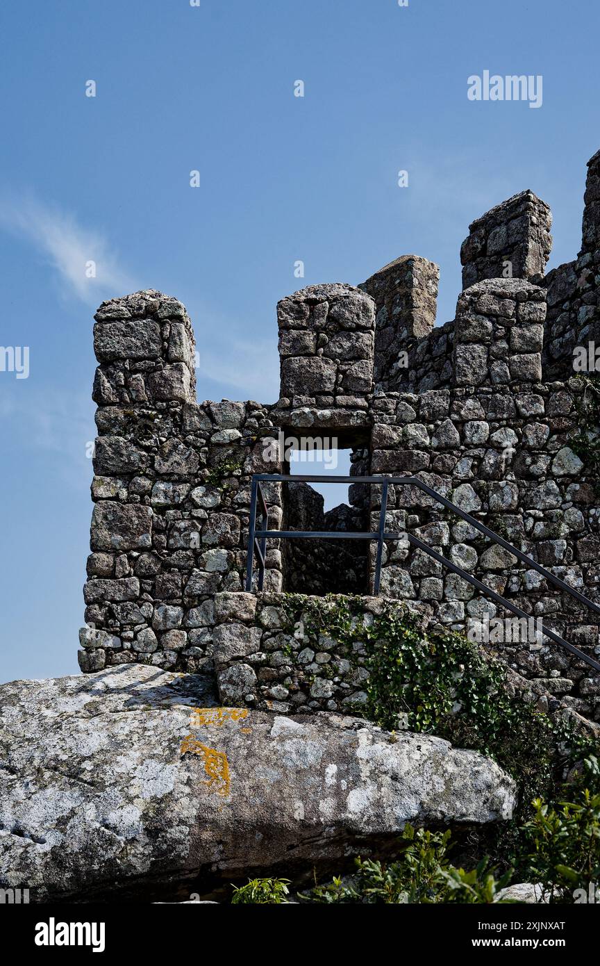 Ein hohler Steinturm mit einem schmalen Durchgang an der maurischen Burg in Sintra, eingerahmt von einem blauen Himmel Stockfoto