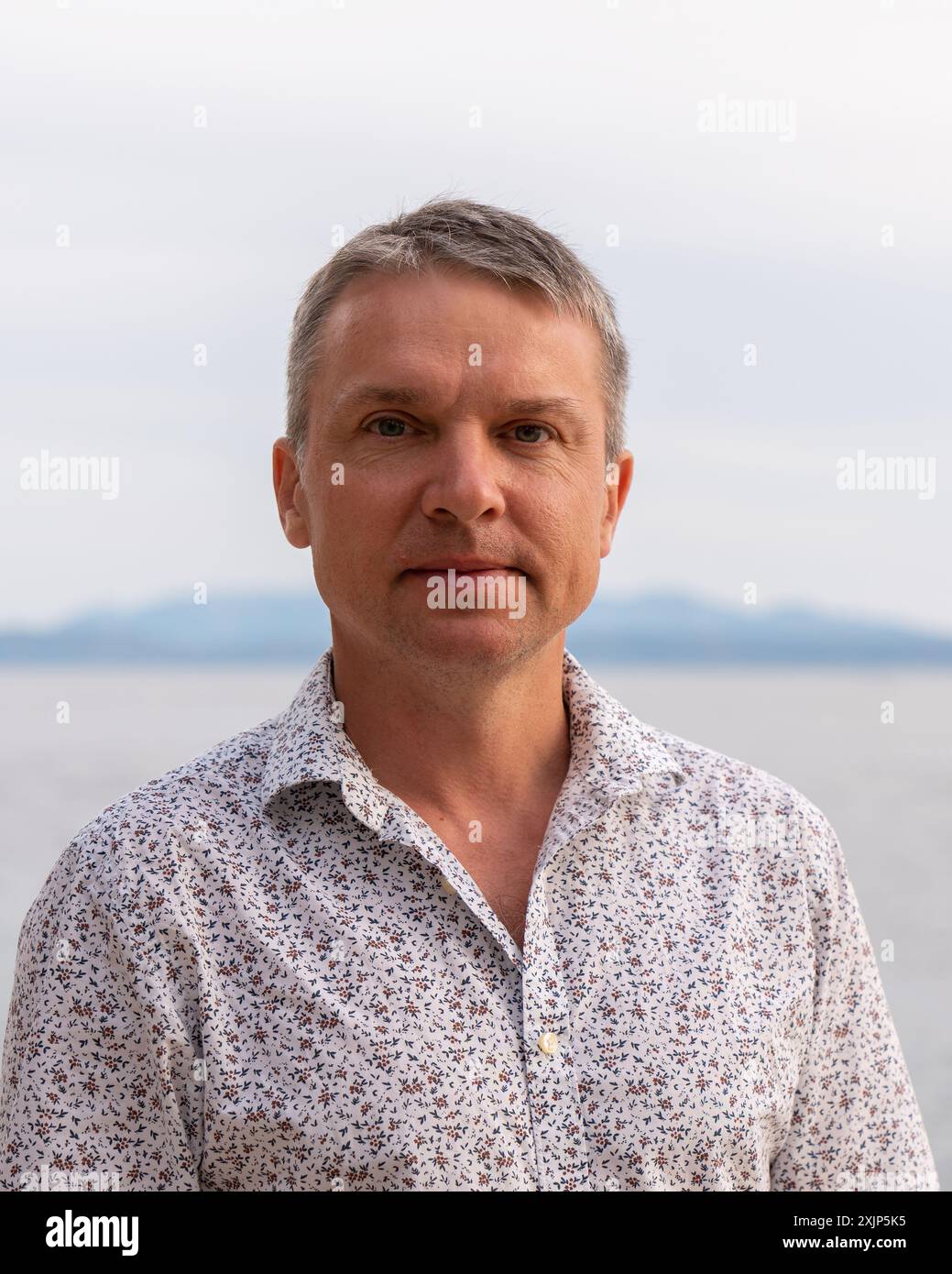 Ein Mann mit einem leichten Hemd am Meer. Stockfoto