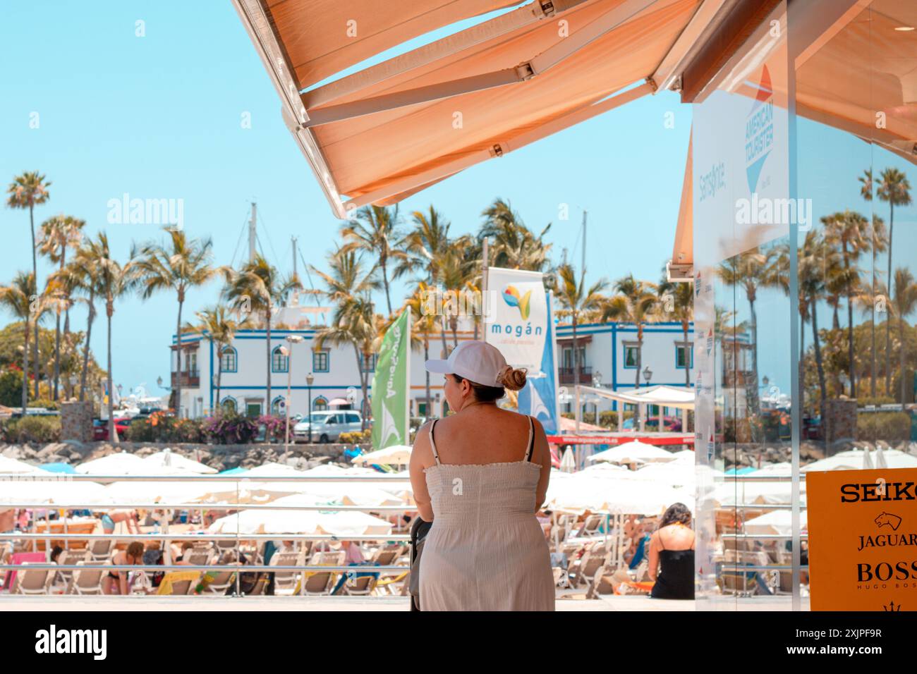 Frau, die im Sommer an einem Touristenstrand auf der Insel Gran Canaria ankommt, um einen Tag am Strand zu genießen Stockfoto