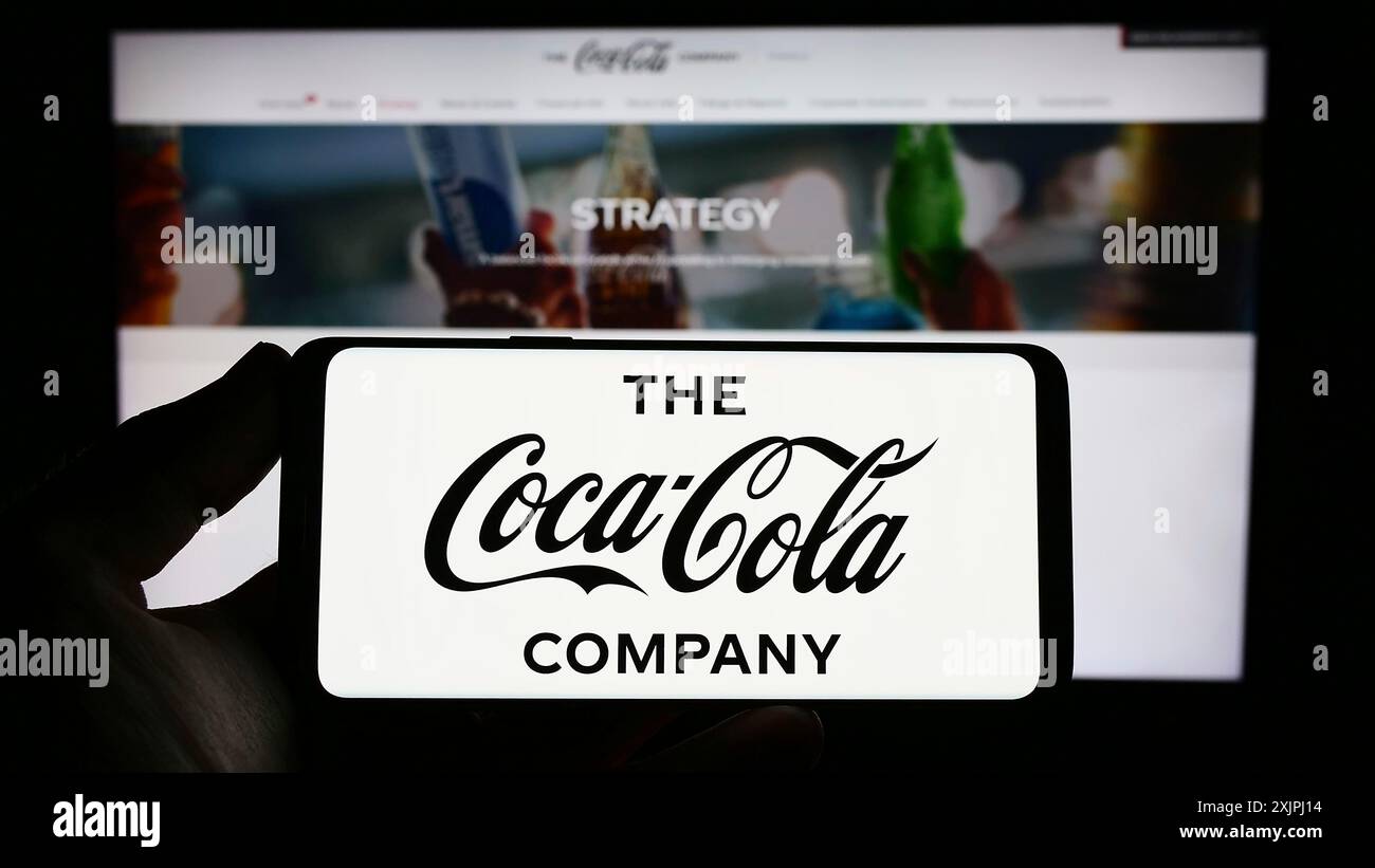 Stuttgart, Deutschland: 25.06.2023: Person, die ein Smartphone mit dem Logo des US-amerikanischen Getränkeherstellers The Coca-Cola Company auf dem Bildschirm vor der Website hält. Stockfoto