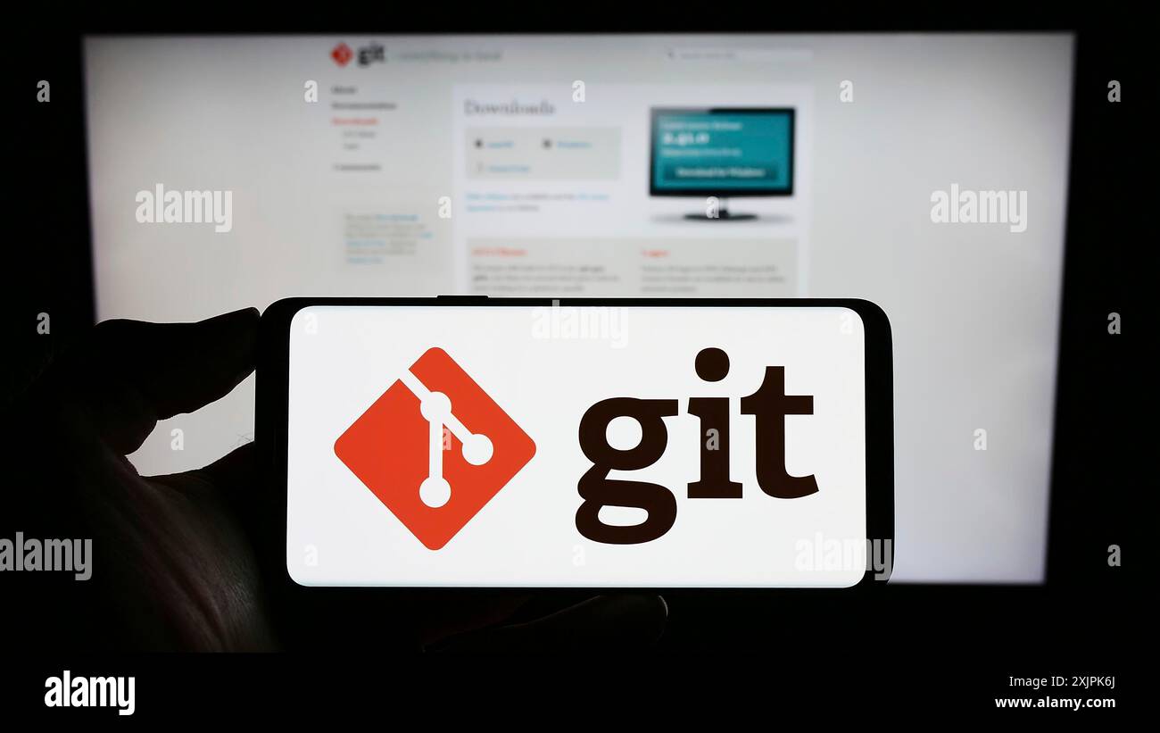 Stuttgart, Deutschland, 07.09.2023: Person, die ein Mobiltelefon mit dem Logo des verteilten Versionskontrollsystems Git auf dem Bildschirm vor der Webseite hält. Fokus Stockfoto