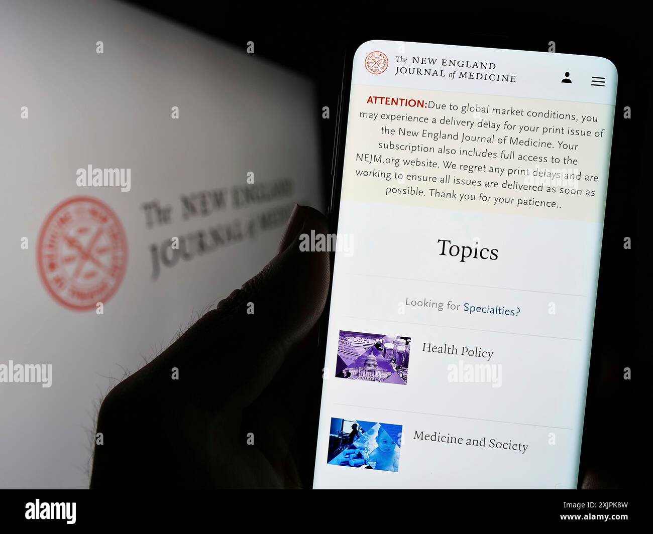 Stuttgart, Deutschland, 07.09.2023: Person mit Smartphone mit Website des New England Journal of Medicine (NEJM) auf dem Bildschirm vor dem Logo. Stockfoto