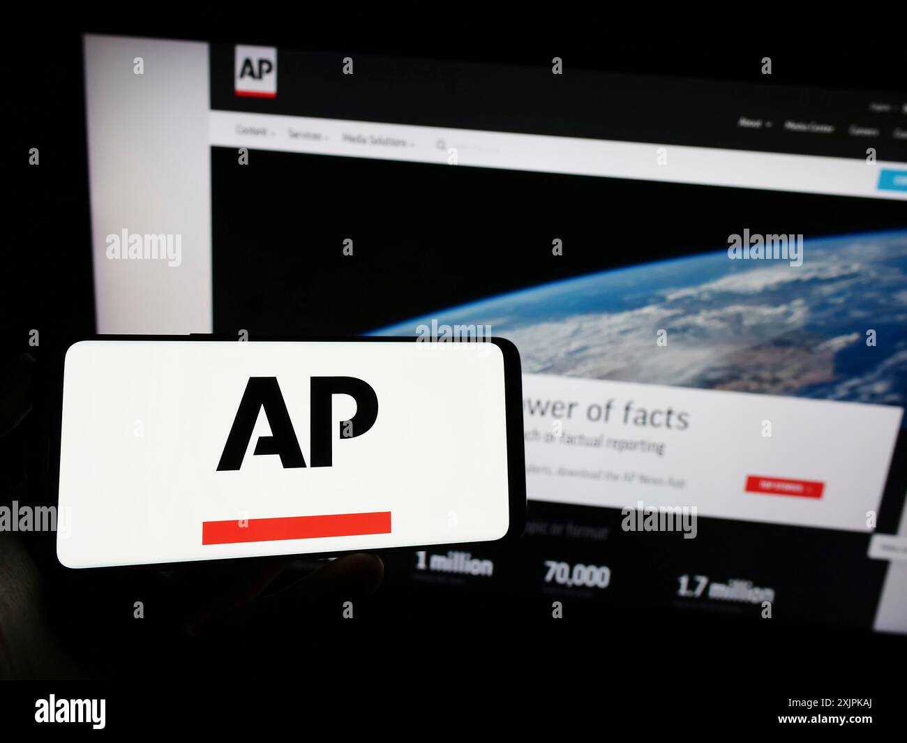 Stuttgart, Deutschland, 07.11.2023: Person, die ein Mobiltelefon mit dem Logo der US-Nachrichtenagentur Associated Press (AP) auf dem Bildschirm vor der Webseite hält. Konzentrieren Sie sich auf Stockfoto