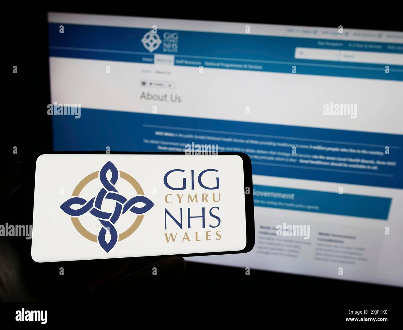 Stuttgart, Deutschland, 07-12-2023: Person, die ein Mobiltelefon mit dem Logo des britischen Gesundheitssystems NHS Wales auf dem Bildschirm vor der Webseite hält. Konzentrieren Sie sich auf Stockfoto