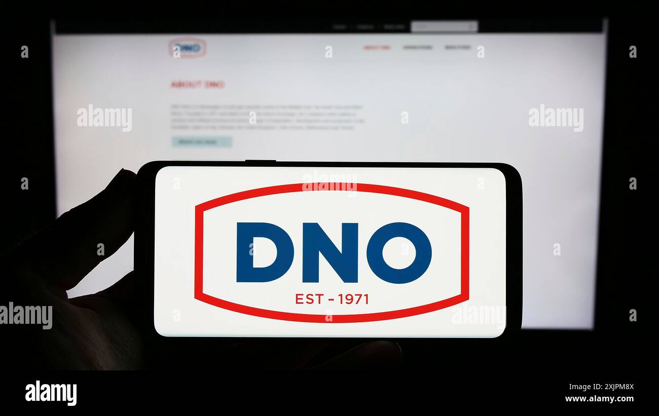 Stuttgart, Deutschland, 21.07.2023: Person, die ein Smartphone mit dem Logo des norwegischen Öl- und Gasunternehmens DNO ASA auf dem Bildschirm vor der Website hält. Konzentrieren Sie sich auf Stockfoto