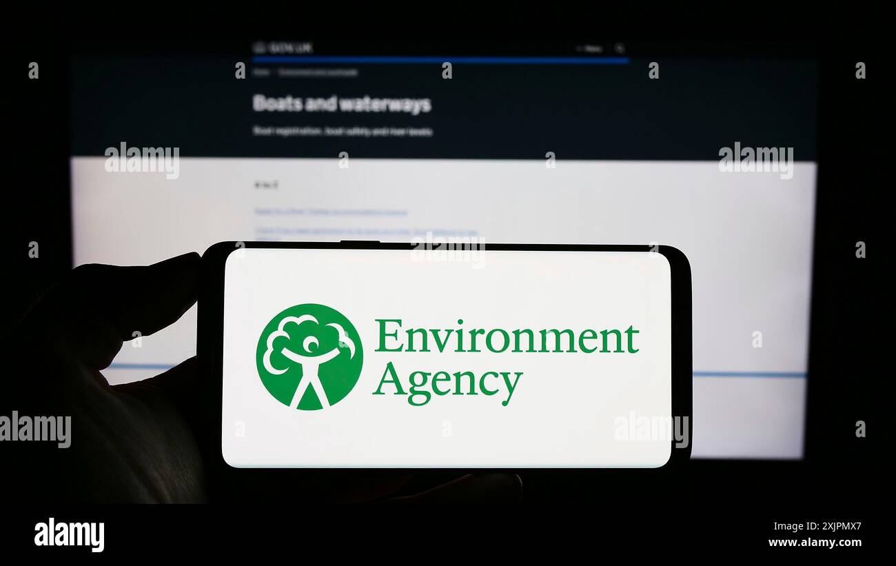 Stuttgart, Deutschland, 07-30-2023: Person, die ein Mobiltelefon mit dem Logo der British Public Body Environment Agency (EA) auf dem Bildschirm vor der Webseite hält. Stockfoto