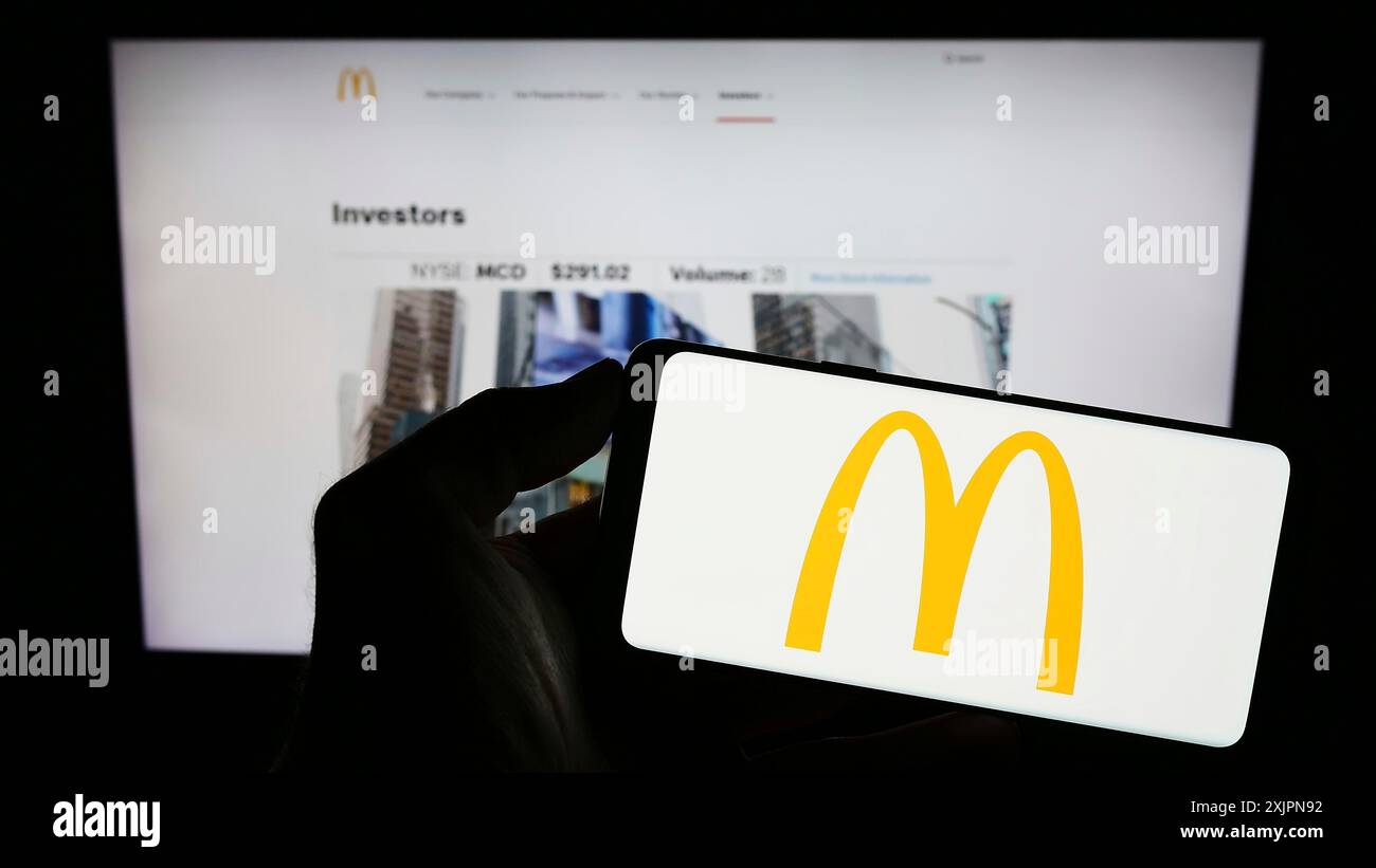 Stuttgart, Deutschland, 08.04.2023: Person, die ein Smartphone mit dem Logo des US-amerikanischen Fast-Food-Unternehmens McDonald's Corporation auf dem Bildschirm vor der Website hält. Stockfoto