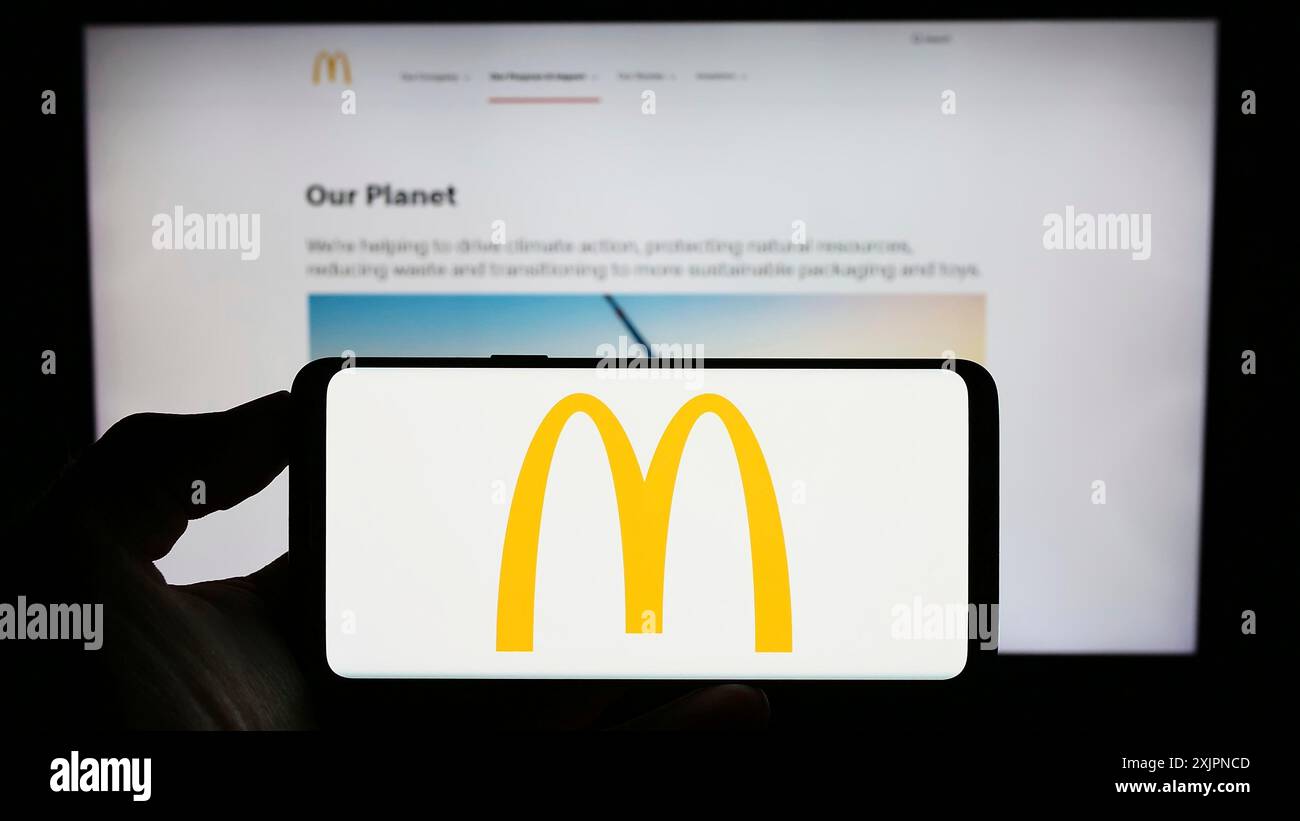 Stuttgart, Deutschland, 08.04.2023: Person, die ein Mobiltelefon mit dem Logo des amerikanischen Fast-Food-Unternehmens McDonald's Corporation auf dem Bildschirm hält Stockfoto