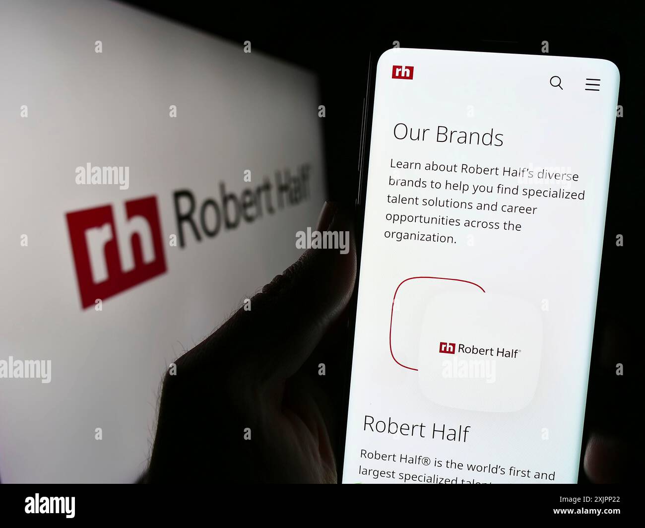 Stuttgart, Deutschland, 08.07.2023: Person mit Smartphone und Website des US-amerikanischen Unternehmens Robert Half International Inc. Auf dem Bildschirm vor dem Logo. Fokus Stockfoto