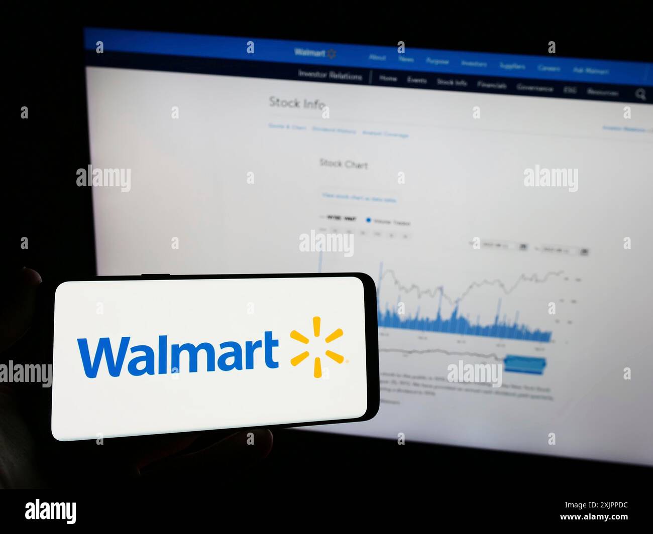 Stuttgart, Deutschland, 13.08.2023: Person, die ein Mobiltelefon mit dem Logo des amerikanischen Einzelhandelsunternehmens Walmart Inc. Auf dem Bildschirm vor dem Business Web hält Stockfoto