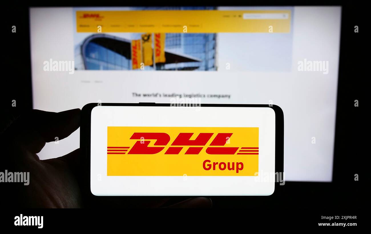 Stuttgart, Deutschland, 20.08.2023: Person mit Smartphone mit Logo des Logistikunternehmens Deutsche Post AG (DHL Group) auf dem Bildschirm vor der Website. Stockfoto