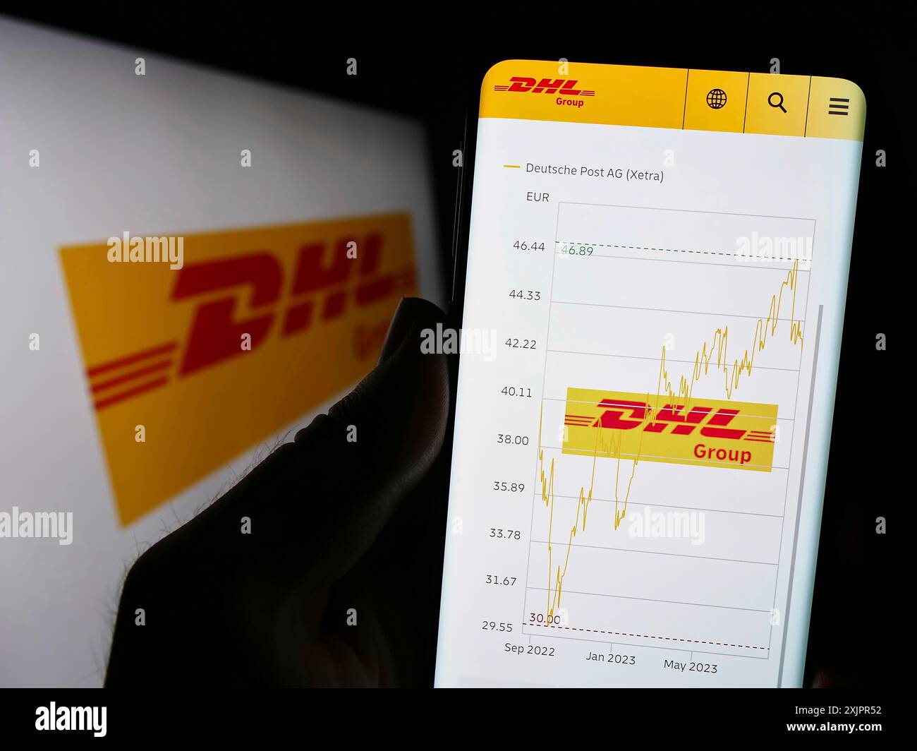 Stuttgart, Deutschland, 20.08.2023: Person, die ein Mobiltelefon hält, mit Webseite des Logistikunternehmens Deutsche Post AG (DHL Group) auf dem Bildschirm mit Logo. Konzentrieren Sie sich auf Stockfoto