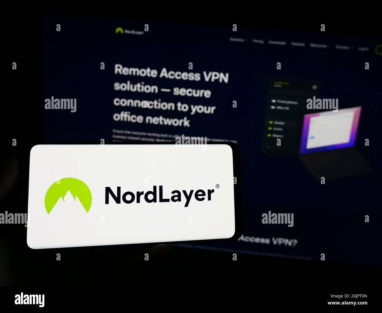 Stuttgart, Deutschland, 09.02.2023: Person, die ein Smartphone mit dem Logo des Netzwerkzugangssicherheitsdienstes NordLayer auf dem Bildschirm vor der Website hält. Fokus Stockfoto