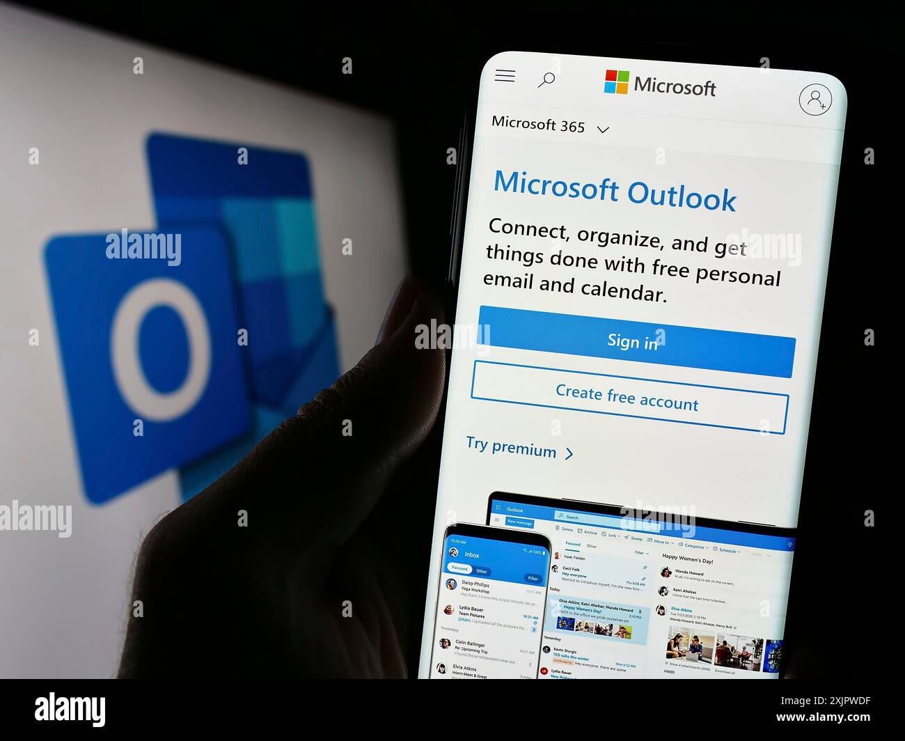 Stuttgart, Deutschland, 21.09.2023: Person, die ein Mobiltelefon hält, auf dem die Webseite der E-Mail-Software Microsoft Outlook vor dem Logo angezeigt wird. Konzentrieren Sie sich auf die Mitte Stockfoto