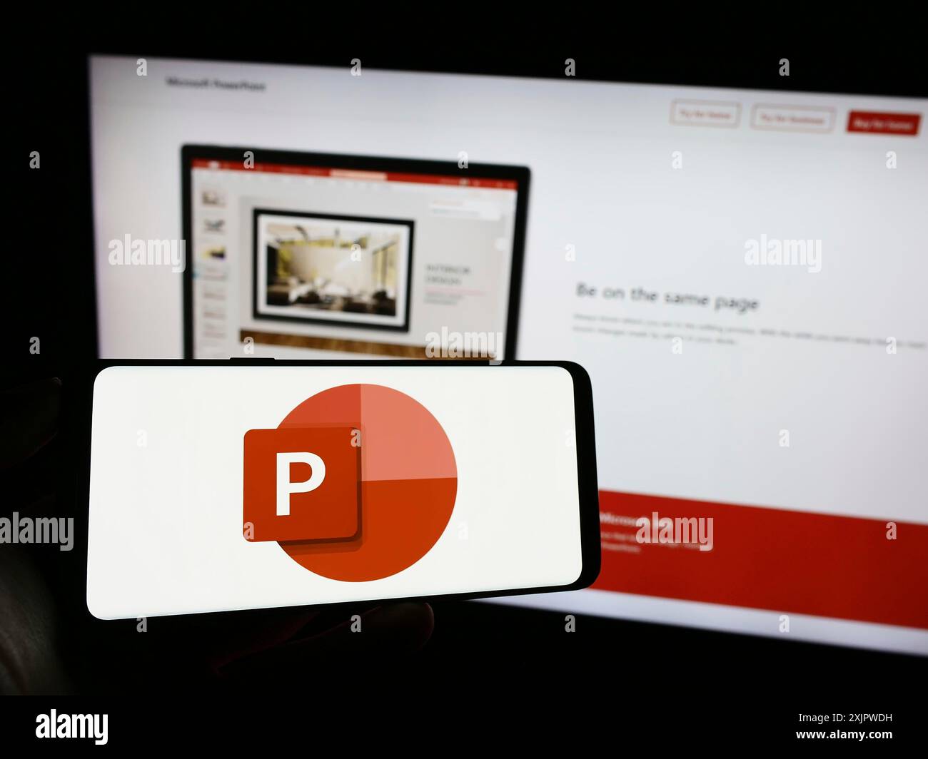 Stuttgart, Deutschland, 21.09.2023: Person mit Mobiltelefon mit Logo der Präsentationssoftware Microsoft PowerPoint auf dem Bildschirm vor dem Unternehmen Stockfoto