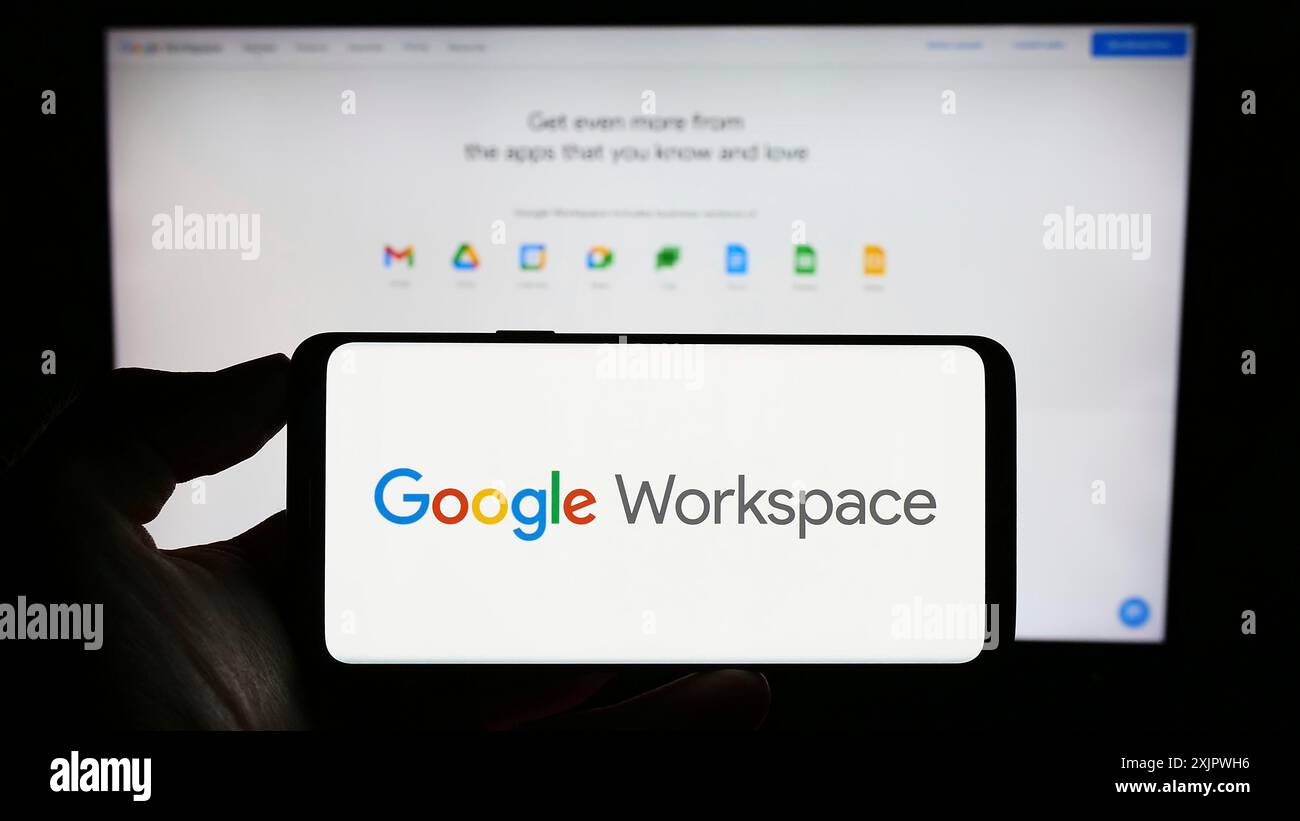 Stuttgart, 23.09.2023: Person, die ein Mobiltelefon mit dem Logo der Business App Software Google Workspace auf dem Bildschirm vor der Business-Website hält. Stockfoto
