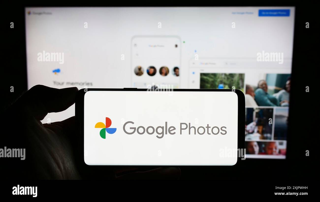 Stuttgart, Deutschland, 23.09.2023: Person, die ein Mobiltelefon mit dem Logo der Bildspeicherplattform Google Photos auf dem Bildschirm vor der Webseite des Unternehmens hält. Stockfoto