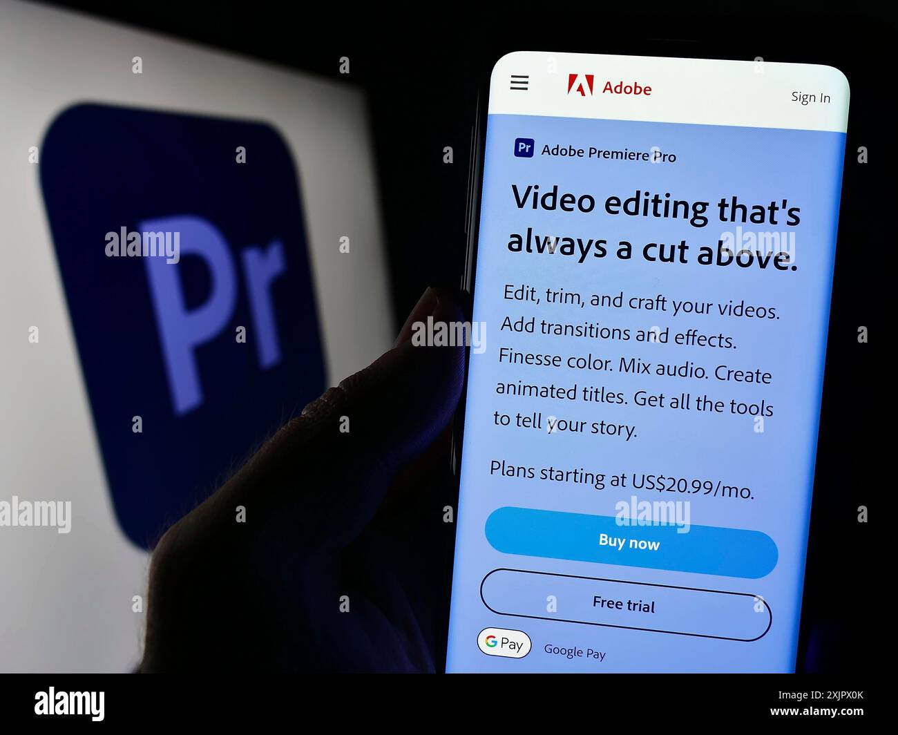 Stuttgart, 23.09.2023: Person, die ein Mobiltelefon hält, auf dem die Webseite der Videobearbeitungssoftware Adobe Premiere Pro vor dem Logo angezeigt wird. Fokus Stockfoto