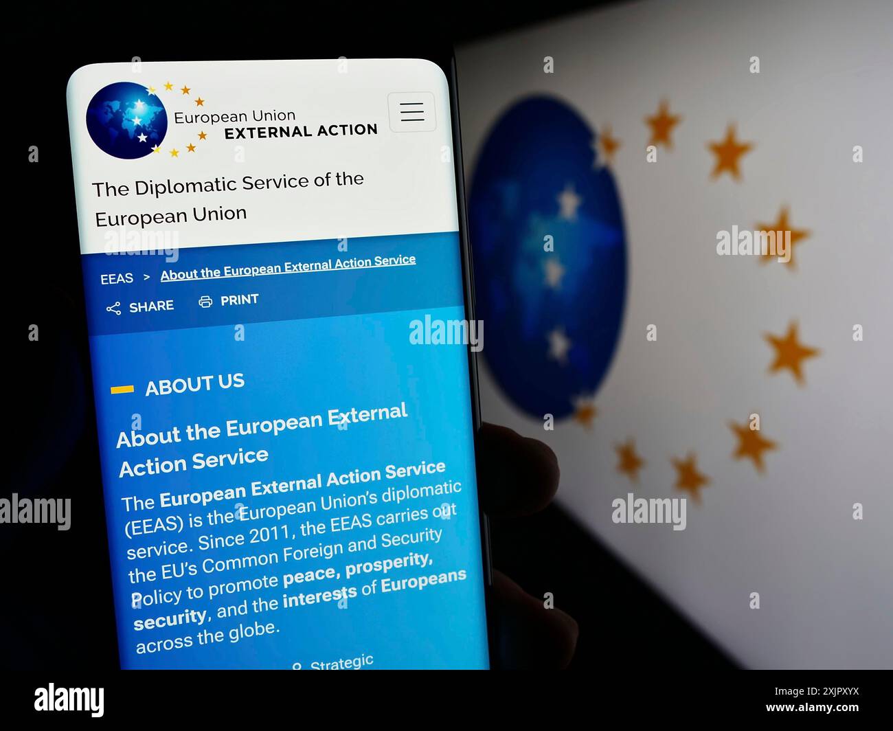 Stuttgart, Deutschland, 10.-16-2023: Person, die ein Mobiltelefon hält, mit Webseite des Europäischen Auswärtigen Dienstes (EAD) der EU-Institution mit Logo. Konzentrieren Sie sich auf Stockfoto