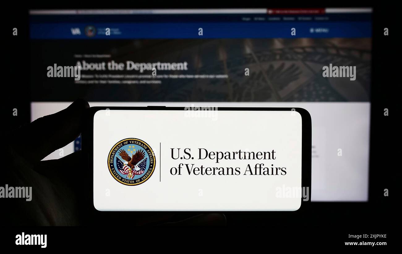 Stuttgart, Deutschland, 10-30-2023: Person, die ein Smartphone mit dem Siegel des United States Department of Veterans Affairs (VA) vor der Website hält. Fokus Stockfoto