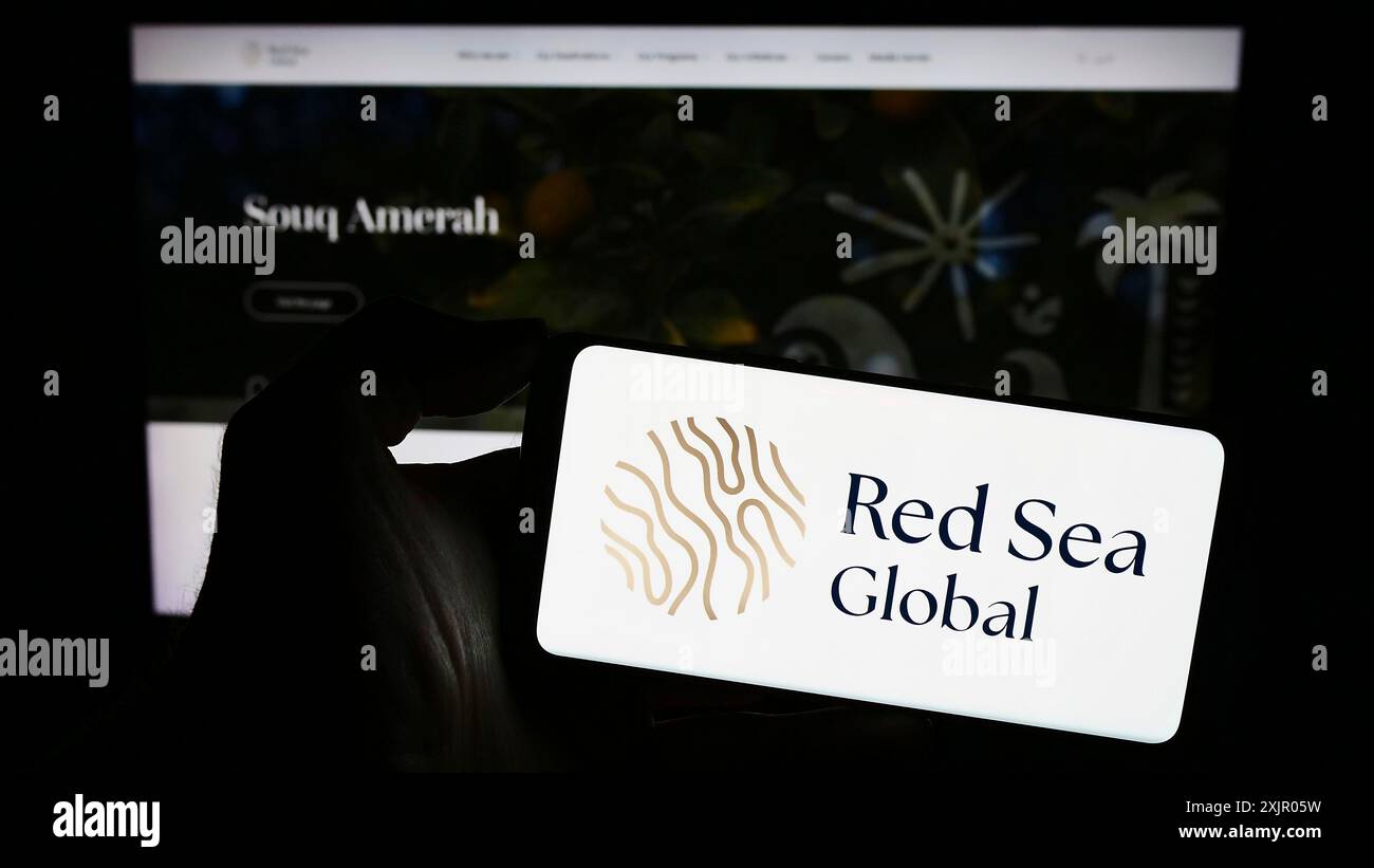Stuttgart, Deutschland, 11.03.2023: Person, die ein Mobiltelefon mit Logo des Saudi-arabischen Entwicklungsunternehmens Red Sea Global vor der Business-Webseite hält. Stockfoto
