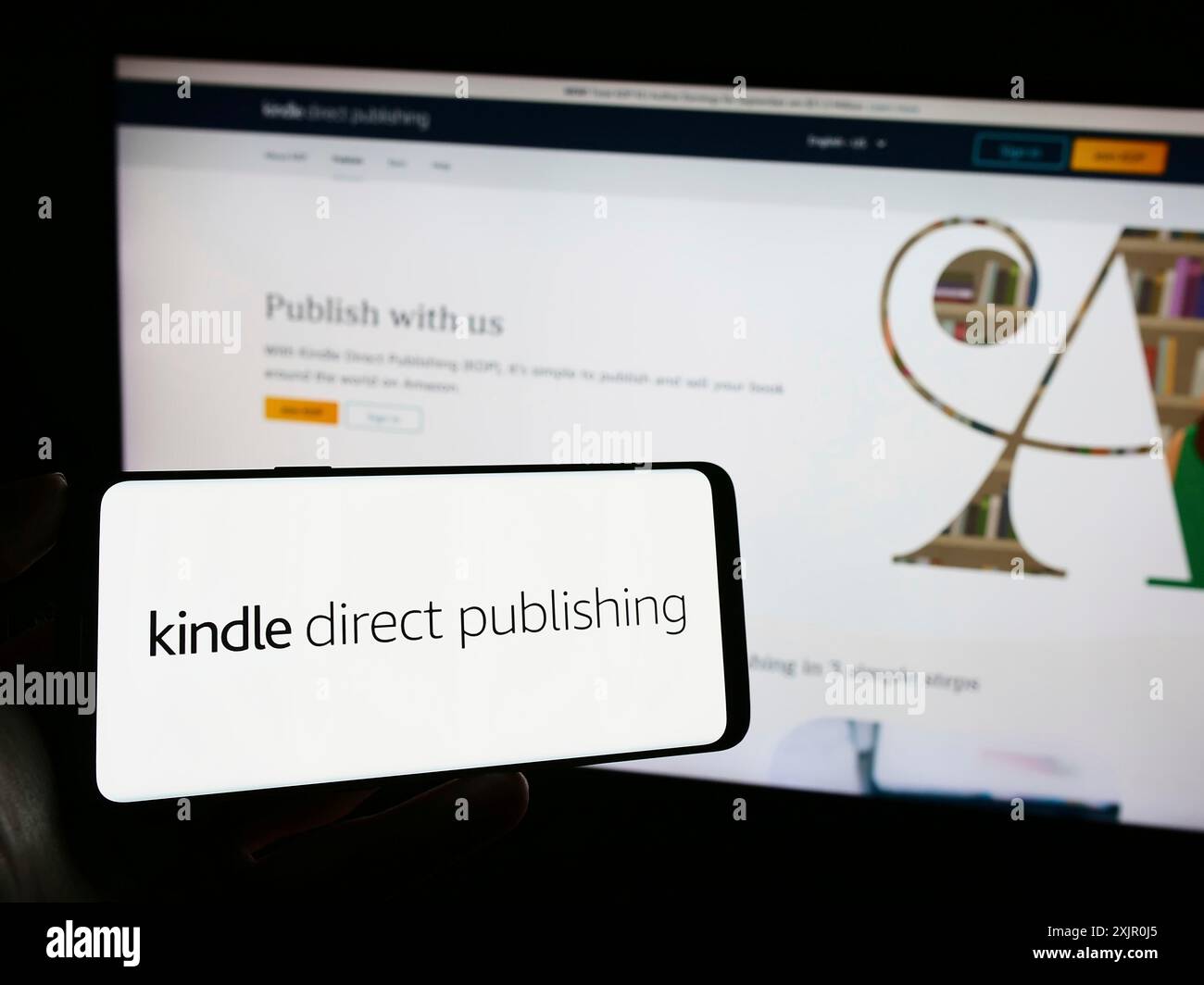 Stuttgart, Deutschland, 11.09.2023: Person mit Mobiltelefon mit Logo der Amazon E-Book-Plattform Kindle Direct Publishing (KDP) vor dem Unternehmen Stockfoto