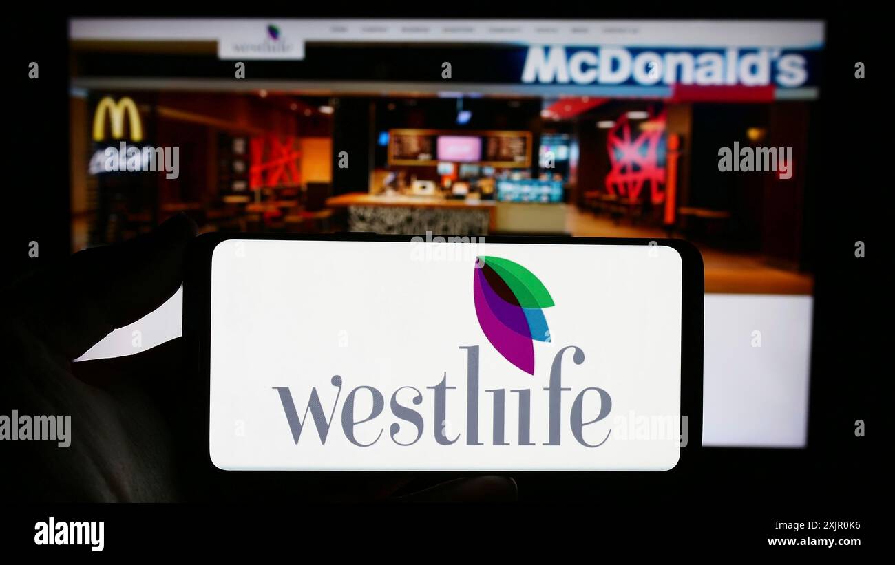 Stuttgart, Deutschland, 11.10.2023: Person, die ein Smartphone mit dem Logo des indischen Fast-Food-Unternehmens Westlife Foodworld Limited vor der Website hält. Fokus Stockfoto