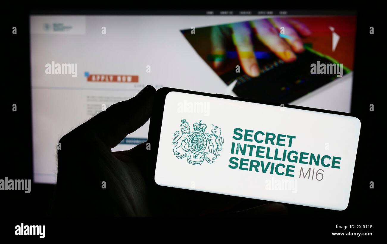 Stuttgart, Deutschland, 11.12.2023: Person, die ein Smartphone mit dem Siegel des britischen Geheimdienstes Secret Intelligence Service (SIS, MI6) vor der Website hält. Stockfoto