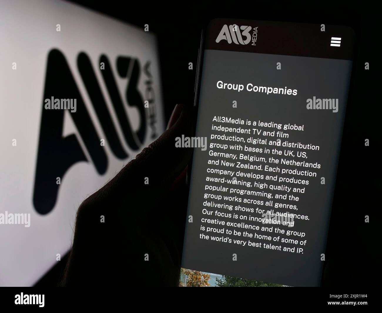 Stuttgart, 27.11.2023: Person, die ein Mobiltelefon mit Webseite des britischen Fernsehproduktionsunternehmens All3Media Limited mit Logo hält. Konzentrieren Sie sich auf Stockfoto