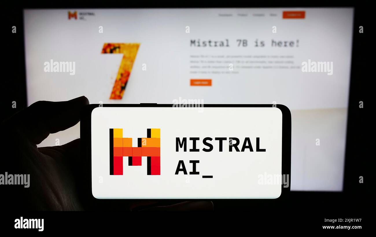 Stuttgart, 27.11.2023: Person, die ein Smartphone mit dem Logo des französischen Künstlichen Intelligenz-Unternehmens Mistral AI SAS vor der Website hält. Stockfoto