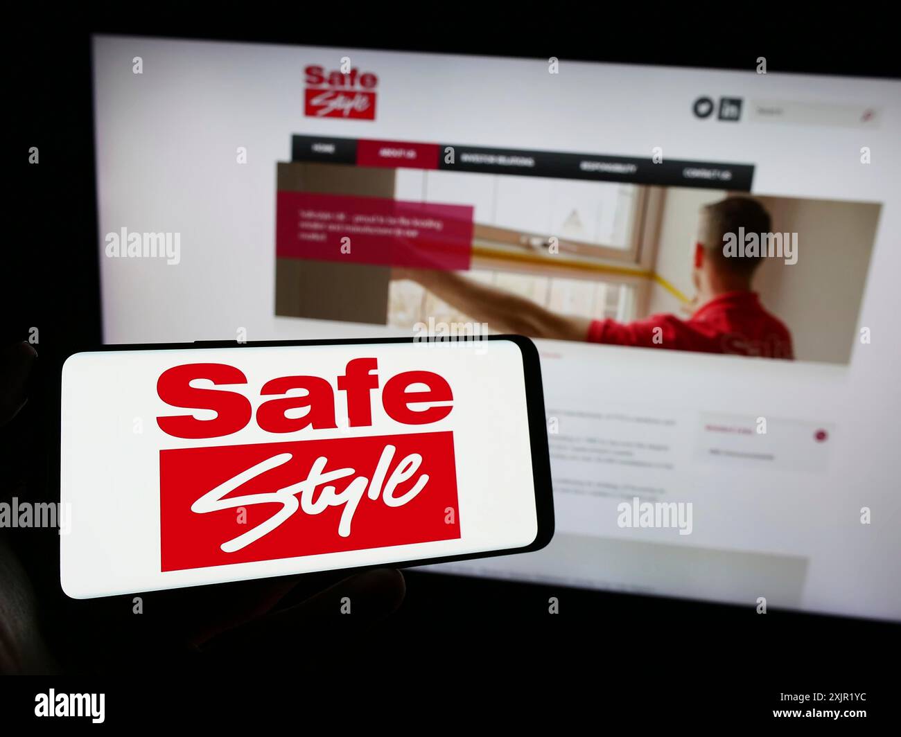 Stuttgart, 24.11.2023: Person, die ein Mobiltelefon mit dem Logo des britischen Windows-Unternehmens Safestyle UK plc vor der Business-Webseite hält. Stockfoto