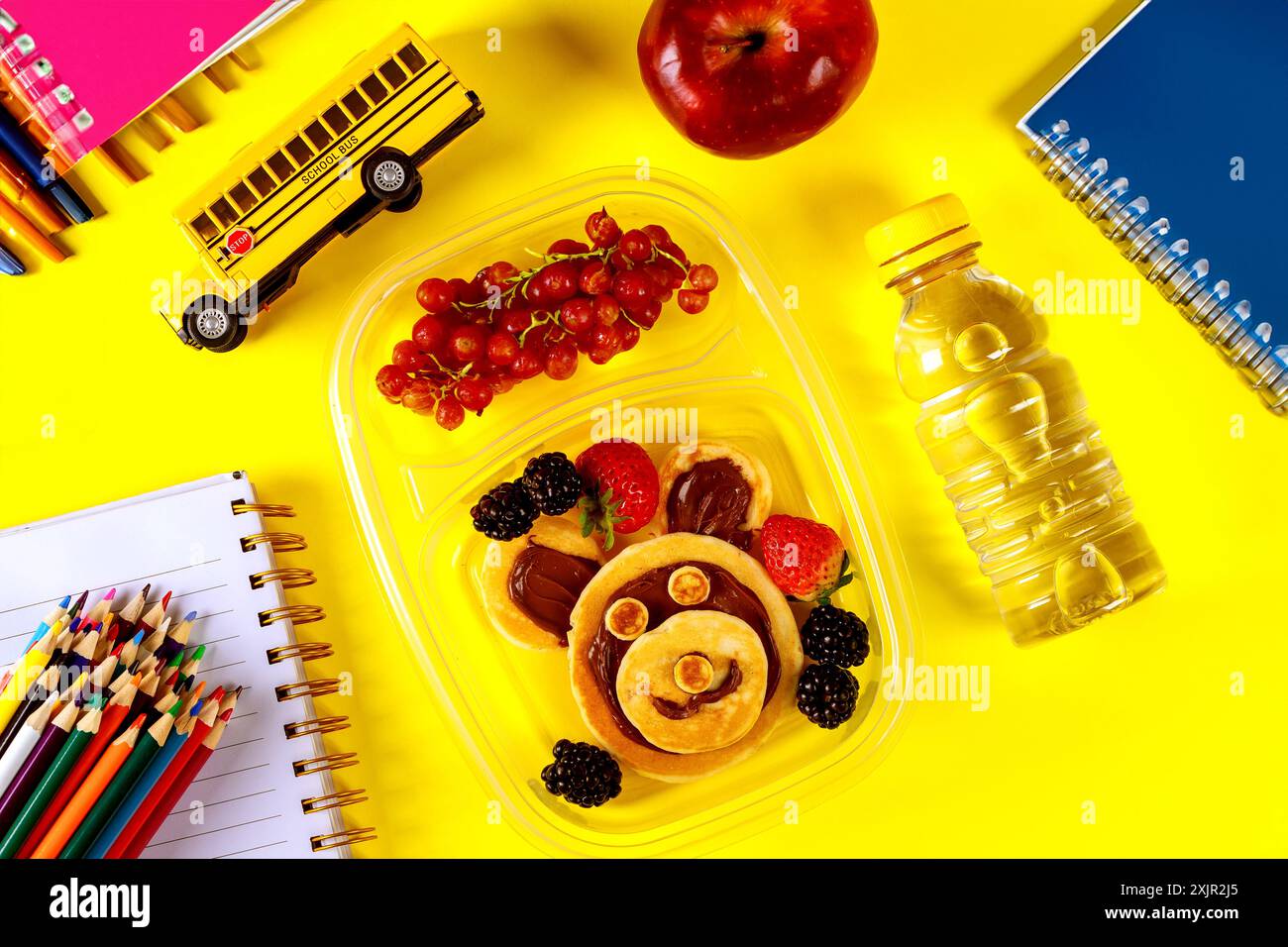 Lunchbox mit Pfannkuchen, Obst und Wasser für die Schule. Stockfoto