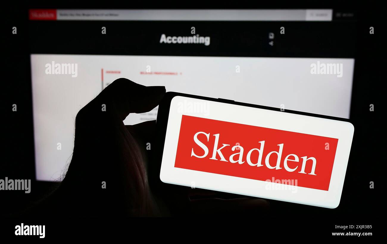 Stuttgart, 17.12.2023: Person mit Mobiltelefon mit Logo der US-amerikanischen Anwaltskanzlei Skadden, Arps, Slate, Meagher und Flom LLP vor der Webseite. Stockfoto