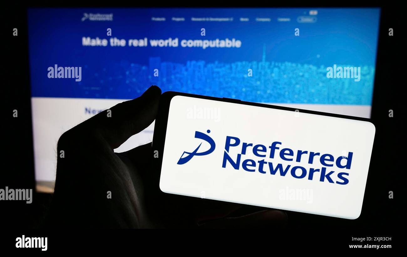 Stuttgart, 18.12.2023: Person, die ein Smartphone mit dem Logo des Künstlichen Intelligenz-Unternehmens Preferred Networks Inc. Vor der Website hält. Stockfoto