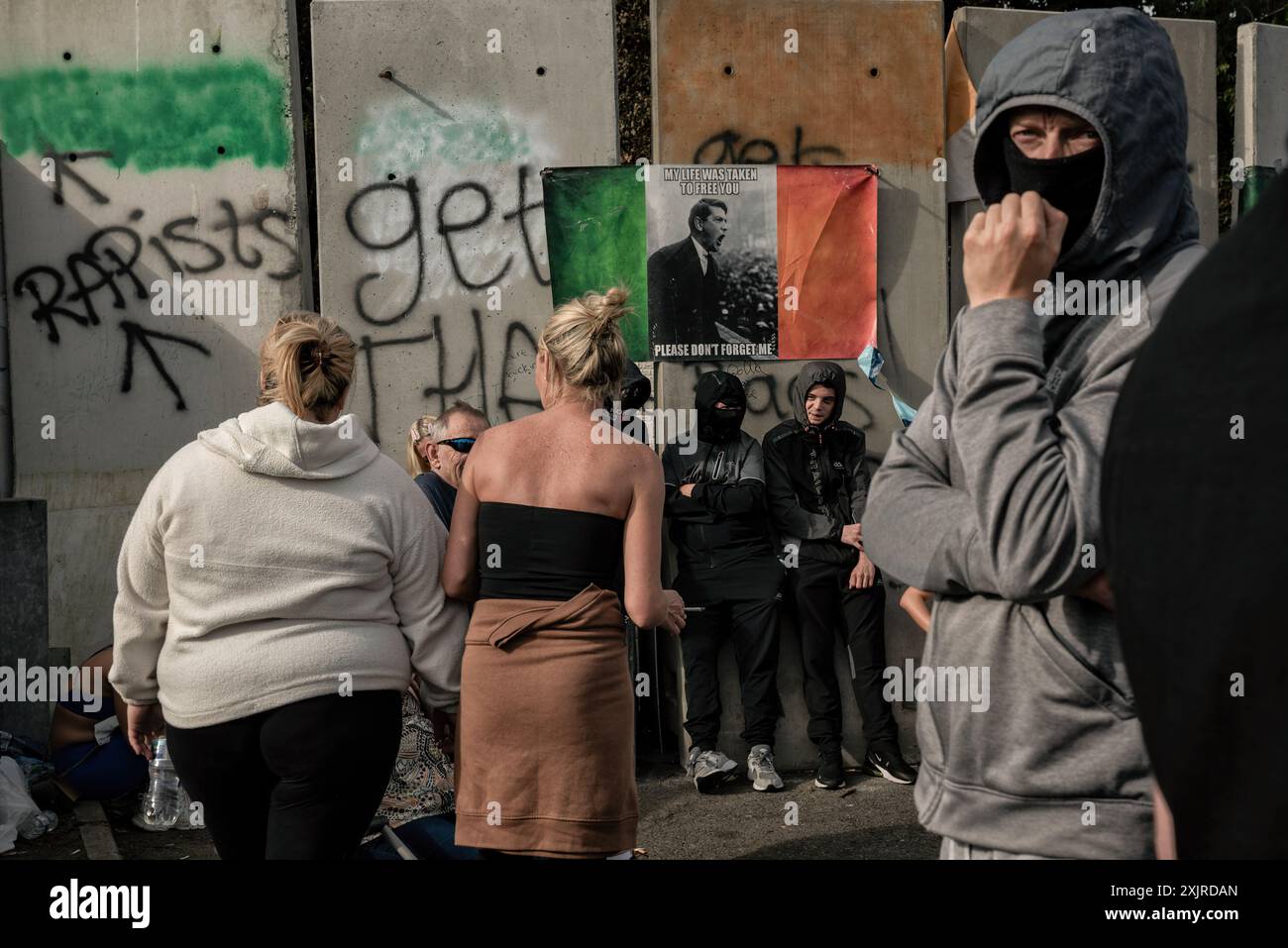 Während der Demonstration stehen Demonstranten vor der ehemaligen Crown Paintanlage. Ein zweiter Protest fand am Freitagabend in Coolock im Norden von Dublin statt. Die Menschen protestieren weiterhin gegen die Wiedereröffnung der ehemaligen Crown Paintanlage, in der Migranten untergebracht werden sollen, und gegen die Masseneinwanderung in Irland. Die Demonstranten, die vom Standort in Richtung Bahnhof Coolock Garda marschierten, beklagten sich auch über die Gewalt, die sie bei dem letzten Protest am 15. Juli erlitten hatten, und forderten die Regierung auf, ihrer Gemeinde mehr Aufmerksamkeit zu schenken. Der heutige Protest wurde friedlich Stockfoto